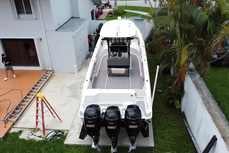 Slide: The Image of 2007 Scarab 35 Sport boat with triple engines parked beside a house. - 33