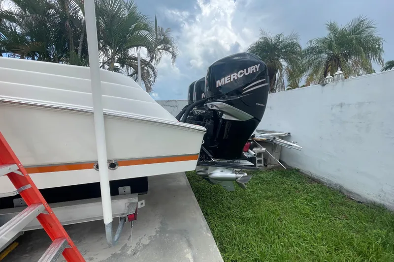 Slide: The Image of 2007 Scarab 35 Sport boat with Mercury outboard motor, parked near palm trees. - 35