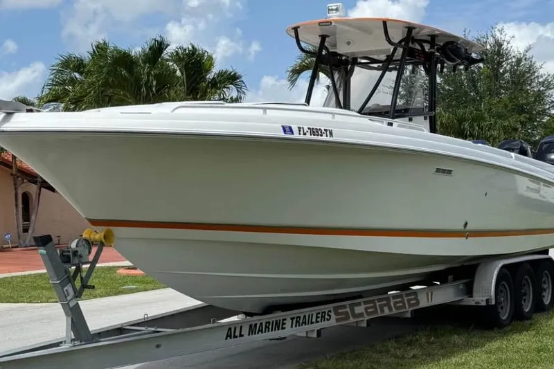 Slide: The Image of 2007 Scarab 35 Sport boat with sleek white design, parked near palm trees. - 5