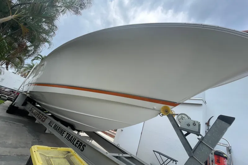 Slide: The Image of 2007 Scarab 35 Sport boat on trailer, parked outdoors under a cloudy sky. - 7