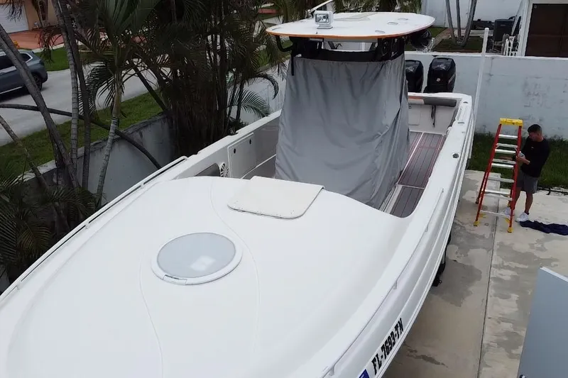 Slide: The Image of 2007 Scarab 35 Sport boat in driveway, surrounded by tropical plants and residential buildings. - 9