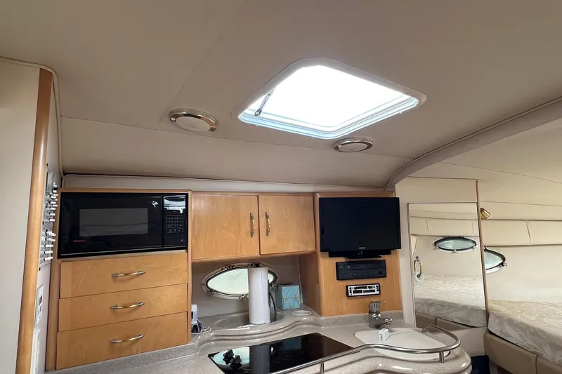 Slide: The Image of Interior of 2000 Larson 330 CABRIO yacht with kitchen and entertainment area. - 14