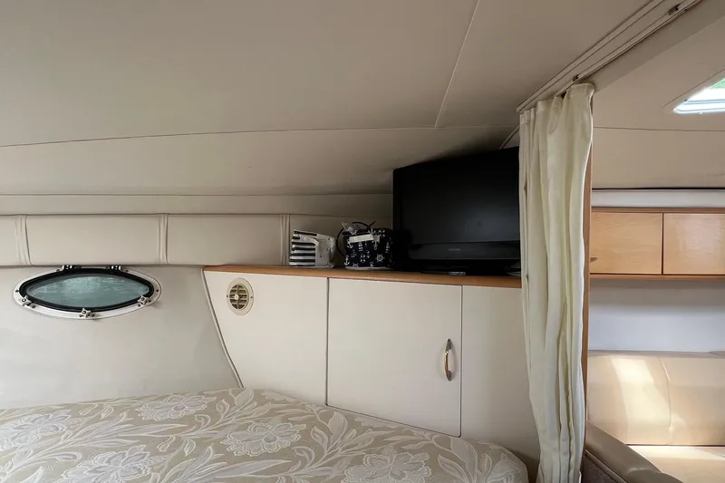 Slide: The Image of Interior of 2000 Larson 330 Cabrio boat with TV, porthole, and bed. - 16