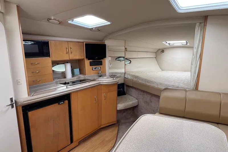Slide: The Image of Interior of 2000 Larson 330 Cabrio boat with kitchenette, bed, and seating area. - 19