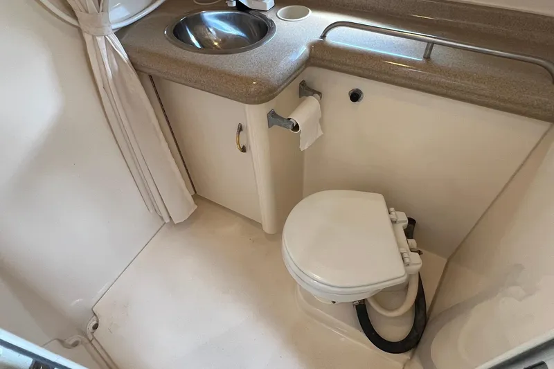 Slide: The Image of 2000 Larson 330 Cabrio boat bathroom with sink and toilet. - 21