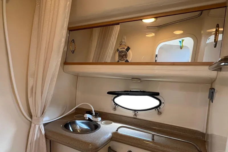 Slide: The Image of 2000 Larson 330 Cabrio boat interior with sink, mirror, and porthole window. - 22