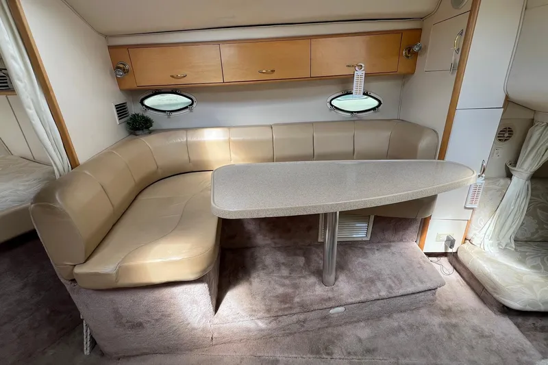 Slide: The Image of Interior of 2000 Larson 330 Cabrio boat with beige seating and oval table. - 24