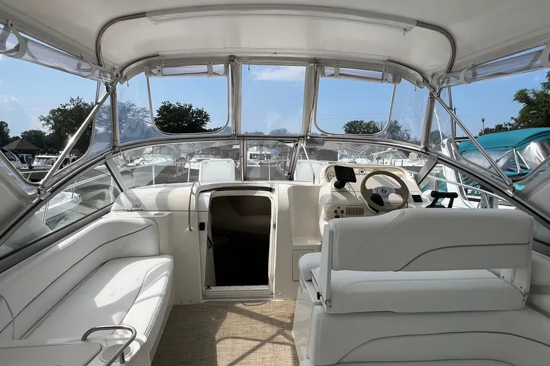 Slide: The Image of Interior view of 2000 Larson 330 CABRIO boat with white seating and steering area. - 25