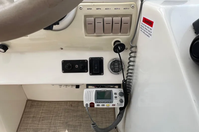 Slide: The Image of Control panel of a 2000 Larson 330 Cabrio boat with switches and radio equipment. - 28