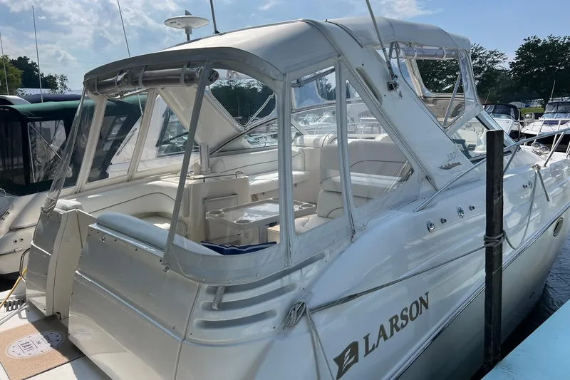 Slide: The Image of Interior of 2000 Larson 330 CABRIO boat with white seating and compact kitchenette. - 3