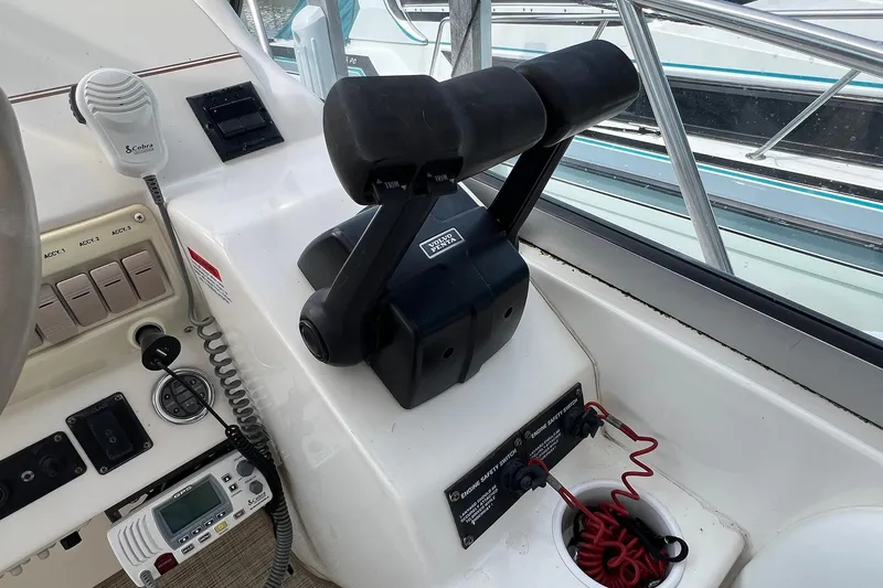 Slide: The Image of Control panel of a 2000 Larson 330 Cabrio boat with throttle and communication equipment. - 31