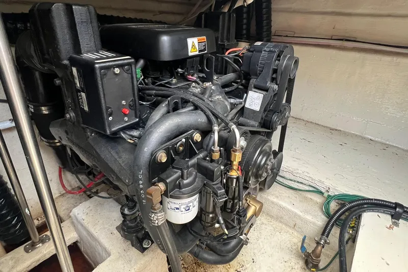 Slide: The Image of Engine compartment of a 2000 Larson 330 CABRIO boat, showcasing detailed mechanical components. - 34