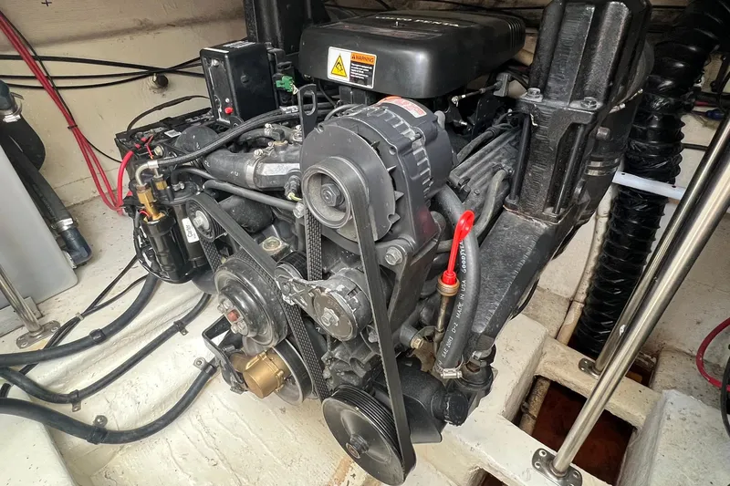 Slide: The Image of Engine compartment of a 2000 Larson 330 CABRIO boat, showcasing mechanical components and wiring. - 36