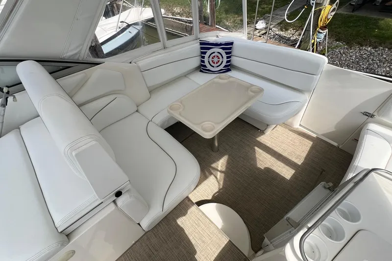 Slide: The Image of 2000 Larson 330 Cabrio boat interior with white seating and a small table. - 9