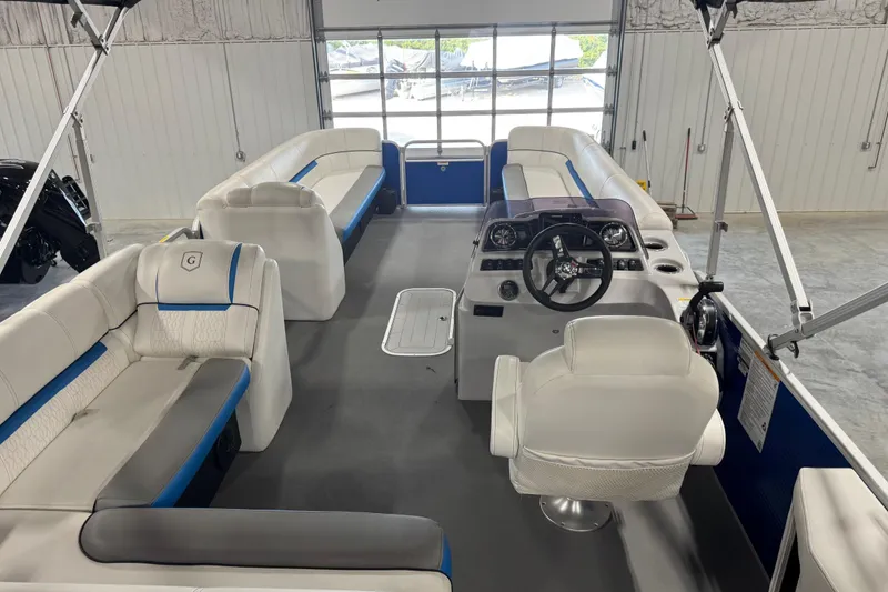 Slide: The Image of 2019 Sweetwater 2486 pontoon boat interior with white seating and steering console. - 11