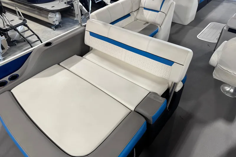 Slide: The Image of 2019 Sweetwater 2486 boat interior with white and blue cushioned seating. - 12