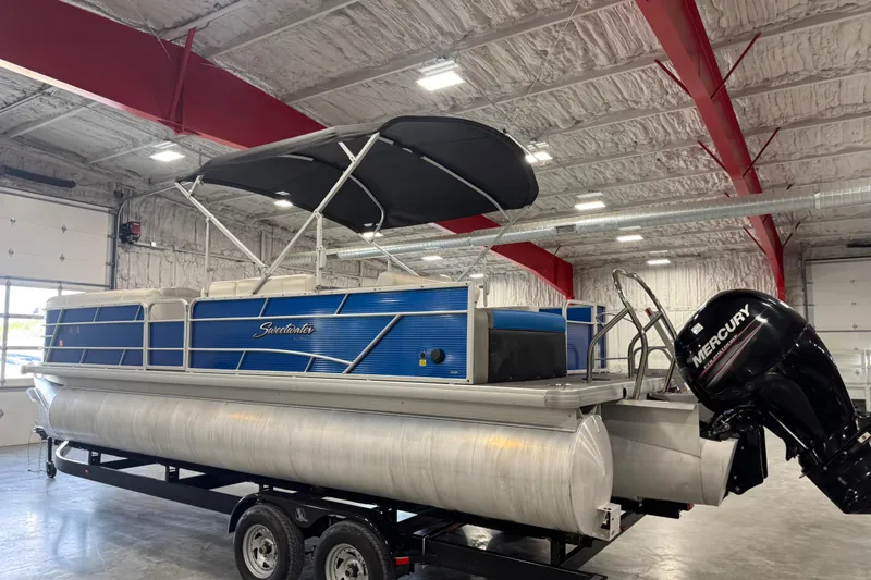 Slide: The Image of 2019 Sweetwater 2486 pontoon boat with Mercury engine in a warehouse setting. - 4