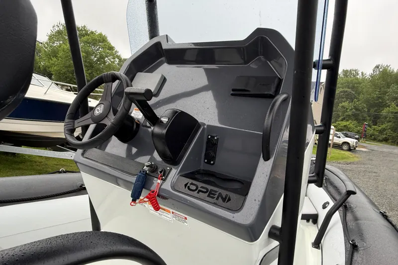 Slide: The Image of 2023 Zodiac Open 5.5 boat console with steering wheel and controls. - 2