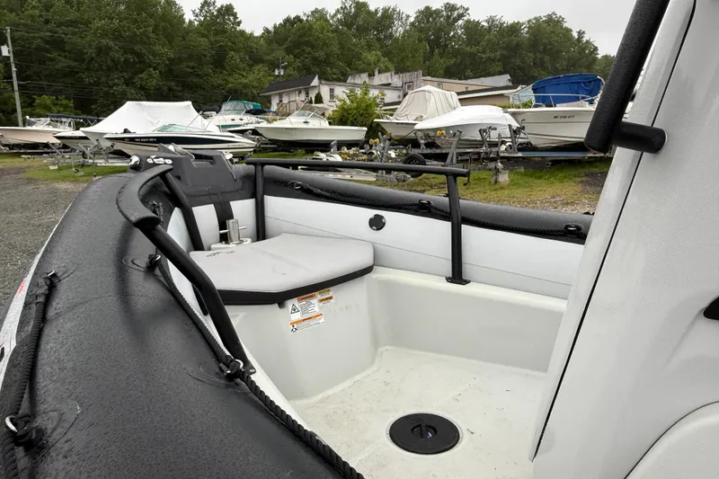 Slide: The Image of 2023 Zodiac Open 5.5 boat interior with seating, surrounded by other boats. - 3