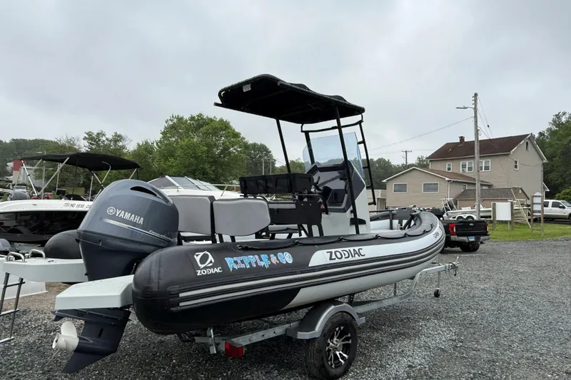 Slide: The Image of 2023 Zodiac Open 5.5 boat with Yamaha engine on a trailer, parked outdoors. - 4