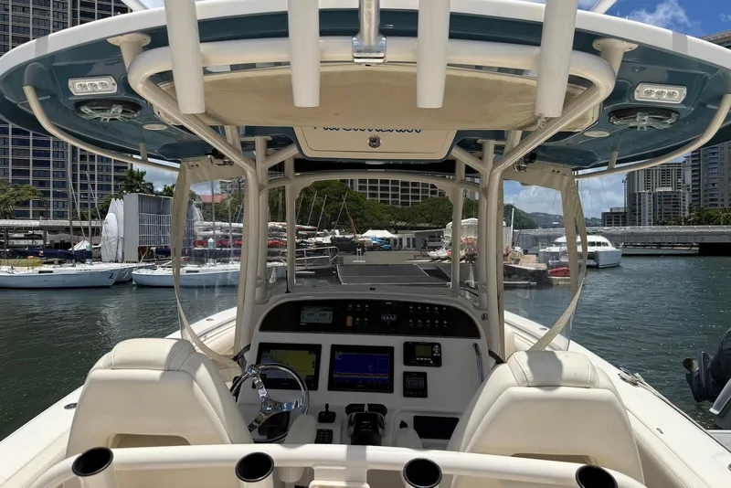 Slide: The Image of 2020 Grady-White Canyon 306 boat interior at marina, featuring helm and seating. - 12