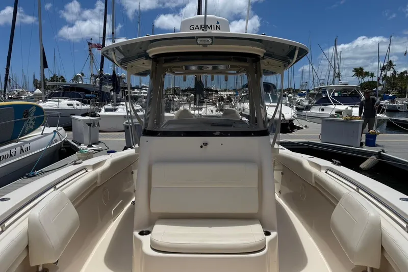 Slide: The Image of 2020 Grady-White Canyon 306 boat docked at a marina under a clear blue sky. - 8