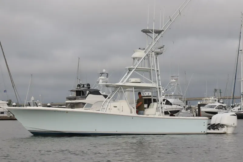 Slide: The Image of 2015 Regulator 34 boat docked in marina, overcast sky, multiple yachts in background. - 1