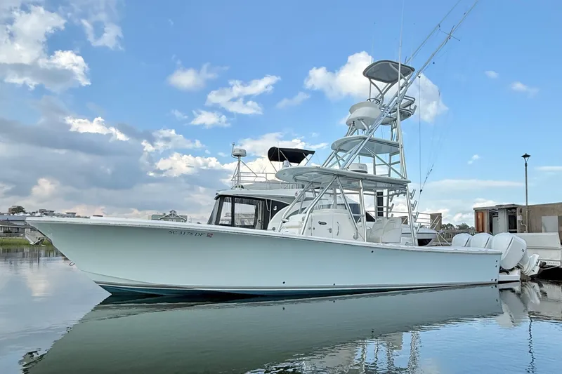 Slide: The Image of 2015 Regulator 34 boat docked on calm water under a partly cloudy sky. - 11