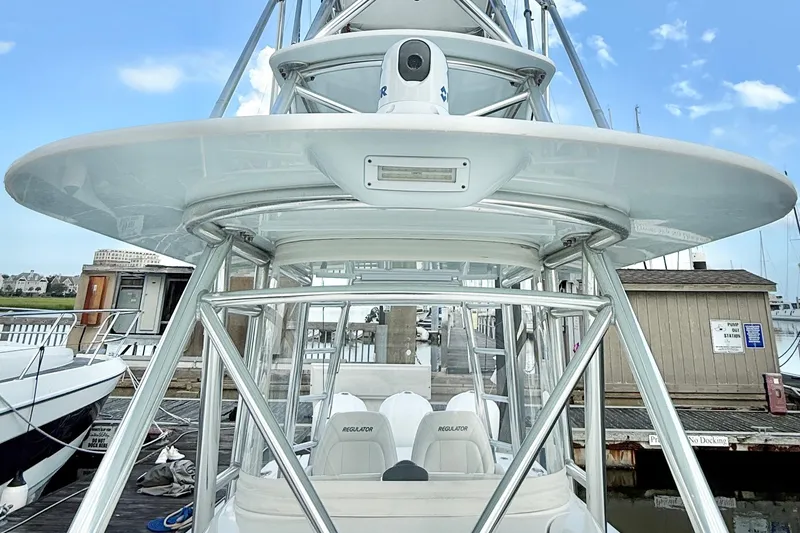 Slide: The Image of 2015 Regulator 34 boat with tower, docked at marina under clear sky. - 14