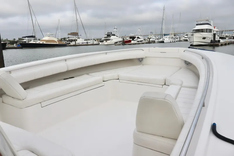 Slide: The Image of 2015 Regulator 34 boat with spacious seating, docked in a marina with other yachts. - 15