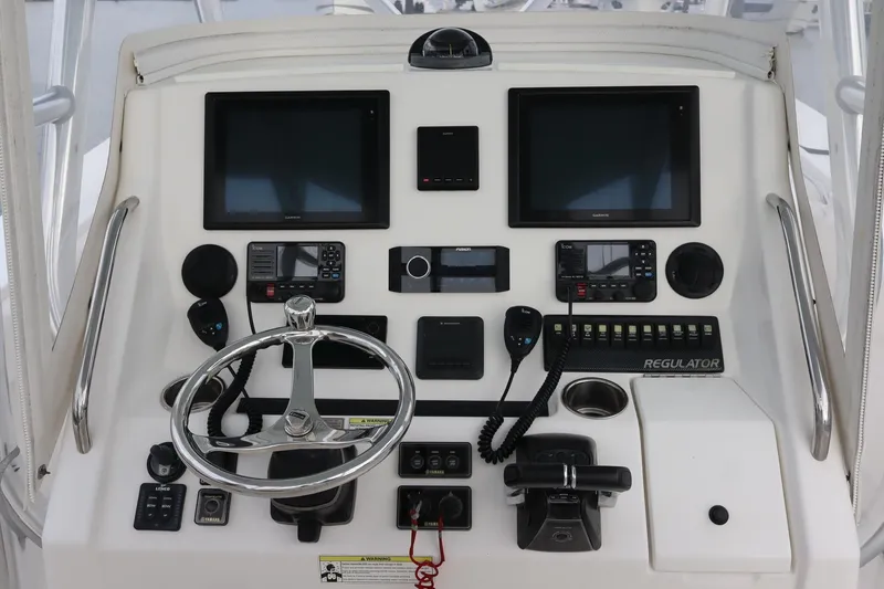 Slide: The Image of Control panel of a 2015 Regulator 34 boat with steering wheel and navigation screens. - 16