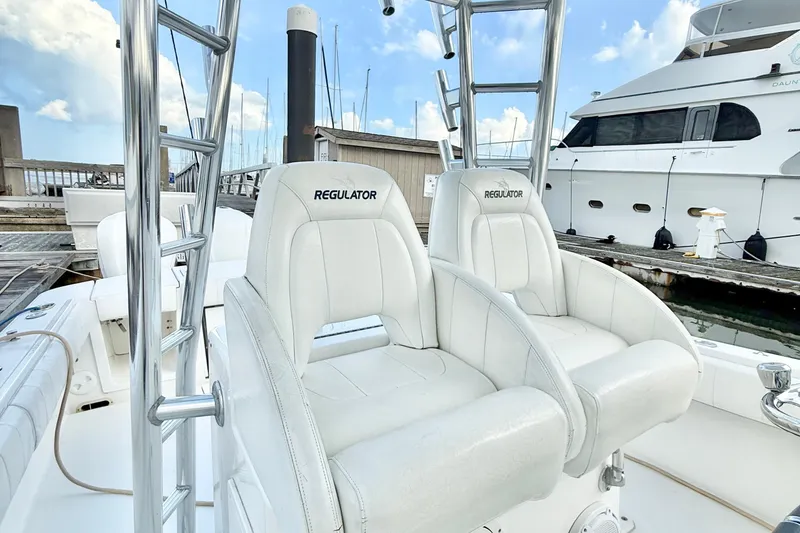Slide: The Image of 2015 Regulator 34 boat with white seating at a marina dock. - 19