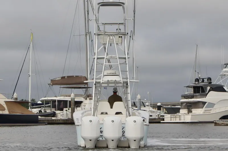 Slide: The Image of 2015 Regulator 34 boat with triple engines docked in a marina. - 2