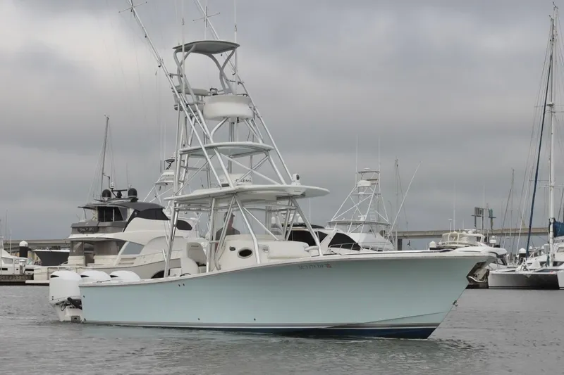 Slide: The Image of 2015 Regulator 34 boat docked in marina, overcast sky, surrounded by other vessels. - 3