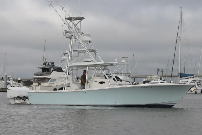 Slide: The Image of 2015 Regulator 34 boat docked in marina, featuring fishing tower and twin engines. - 5