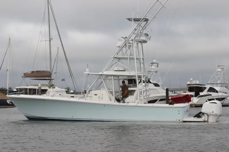 Slide: The Image of 2015 Regulator 34 boat docked in marina, overcast sky, multiple yachts in background. - 7