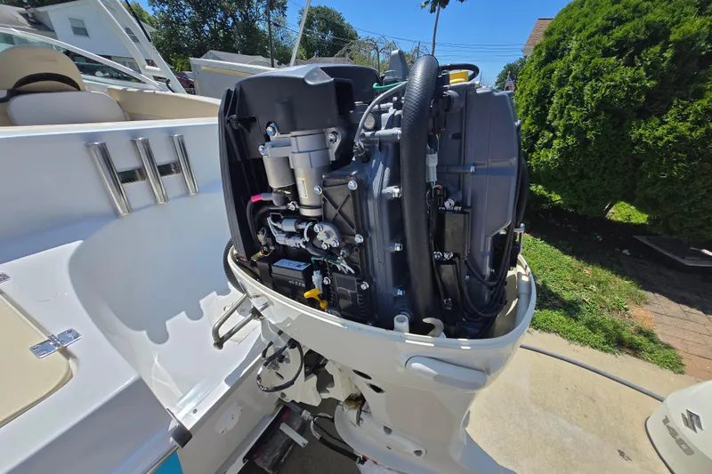 Slide: The Image of 2021 Caravelle 19 EBo Bowrider with exposed outboard motor, showcasing engine details. - 12