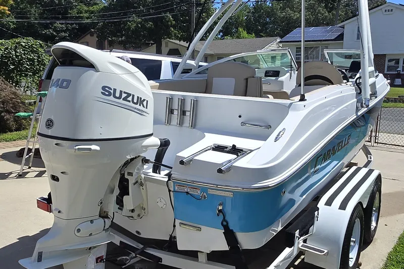 Slide: The Image of 2021 Caravelle 19 EBo Bowrider with Suzuki outboard motor on trailer. - 2