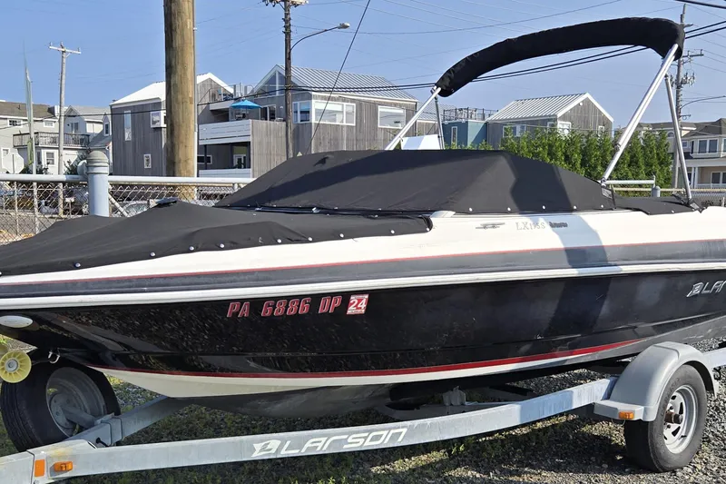 Slide: The Image of 2014 Larson LX 195S IO boat on trailer, covered and parked outdoors. - 11