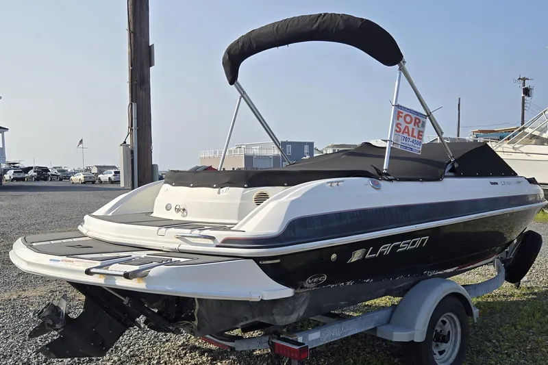 Slide: The Image of 2014 Larson LX 195S IO boat for sale, black and white, on trailer. - 2