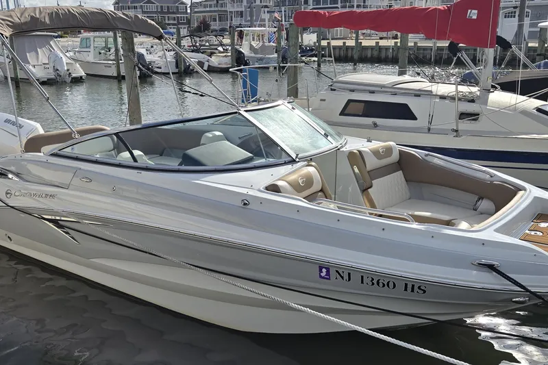The Image of 2023 Crownline Eclipse E235 XS boat docked in marina, featuring sleek design and comfortable seating. - 0
