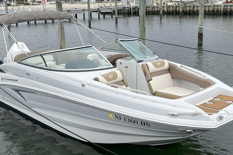 Slide: The Image of 2023 Crownline Eclipse E235 XS boat docked in marina, featuring sleek design and comfortable seating. - 5