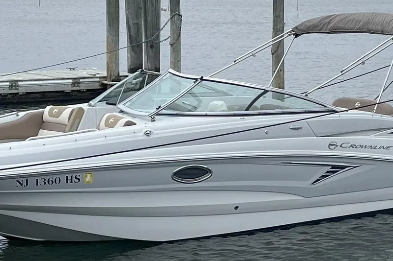 Slide: The Image of 2023 Crownline Eclipse E235 XS boat docked, featuring sleek design and comfortable seating. - 6