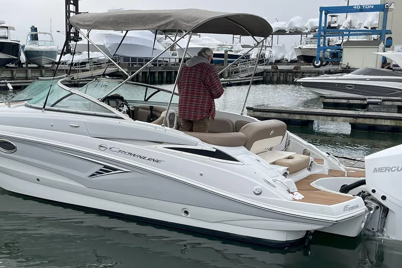 Slide: The Image of 2023 Crownline Eclipse E235 XS boat docked at marina with canopy and Mercury engine. - 7