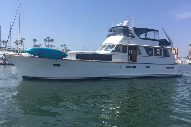 The Image of 1974 Chris-Craft Roamer yacht docked in marina, featuring a sleek design and blue kayak. - 0