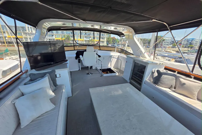 Slide: The Image of Luxurious 1974 Chris-Craft Roamer yacht interior with seating, TV, and marina view. - 2