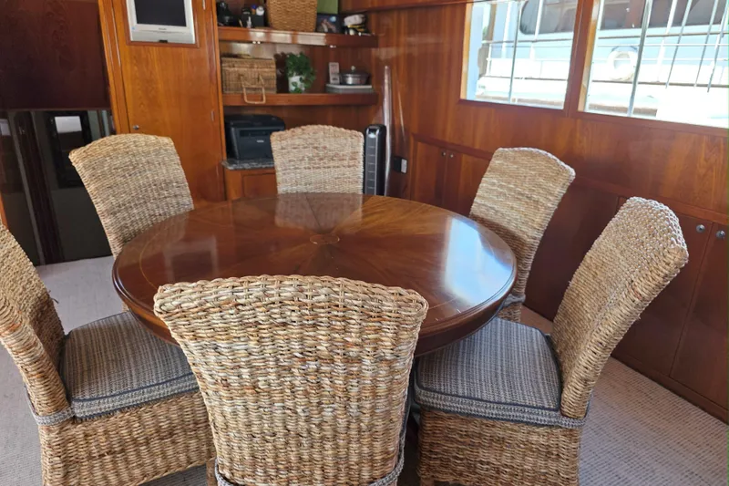 Slide: The Image of 1974 Chris-Craft Roamer yacht interior with wicker chairs and wooden dining table. - 3