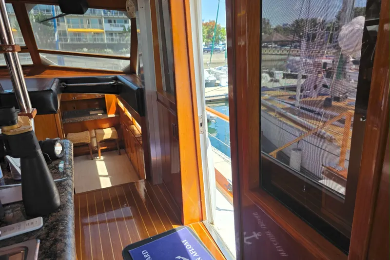 Slide: The Image of Interior view of a 1974 Chris-Craft Roamer yacht with wooden finishes and marina view. - 6