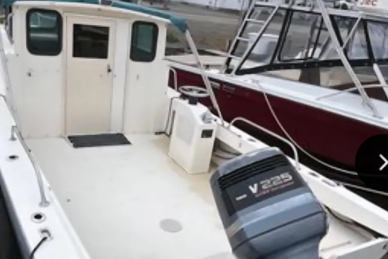 The Image of 2001 Parker 2520 Modified Vee Sport Cabin boat with V225 engine, docked. - 0