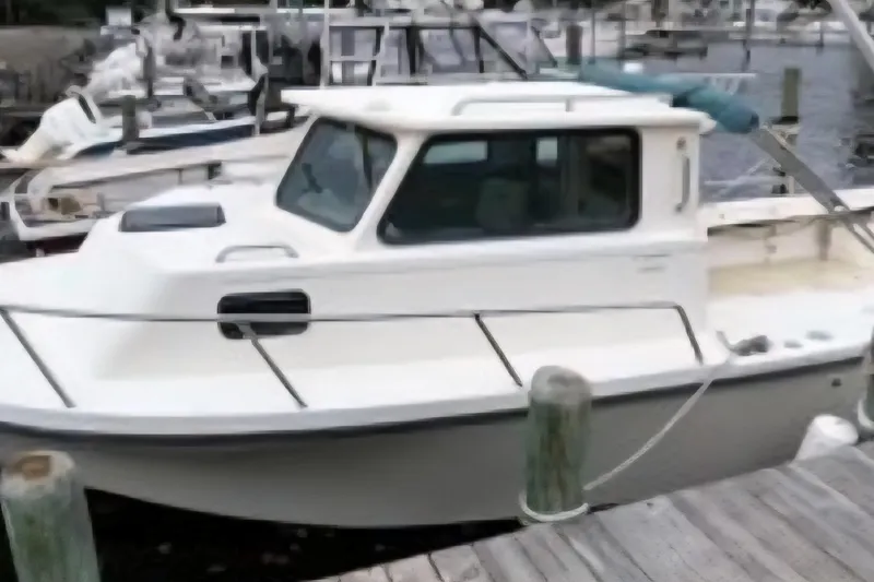 Slide: The Image of 2001 Parker 2520 Modified Vee Sport Cabin boat docked at marina. - 2